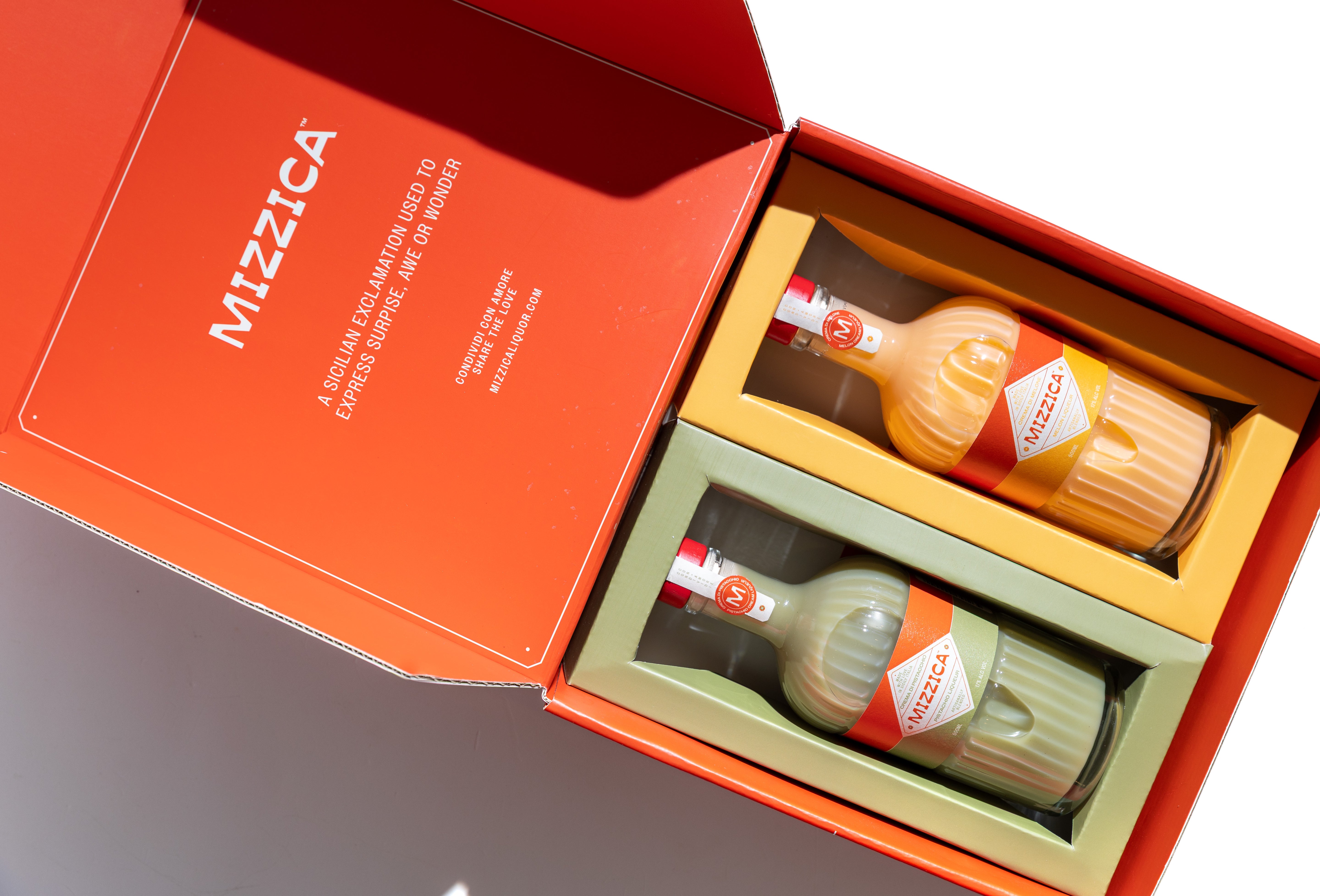 Two Mizzica liqueur bottles in a branded gift box.