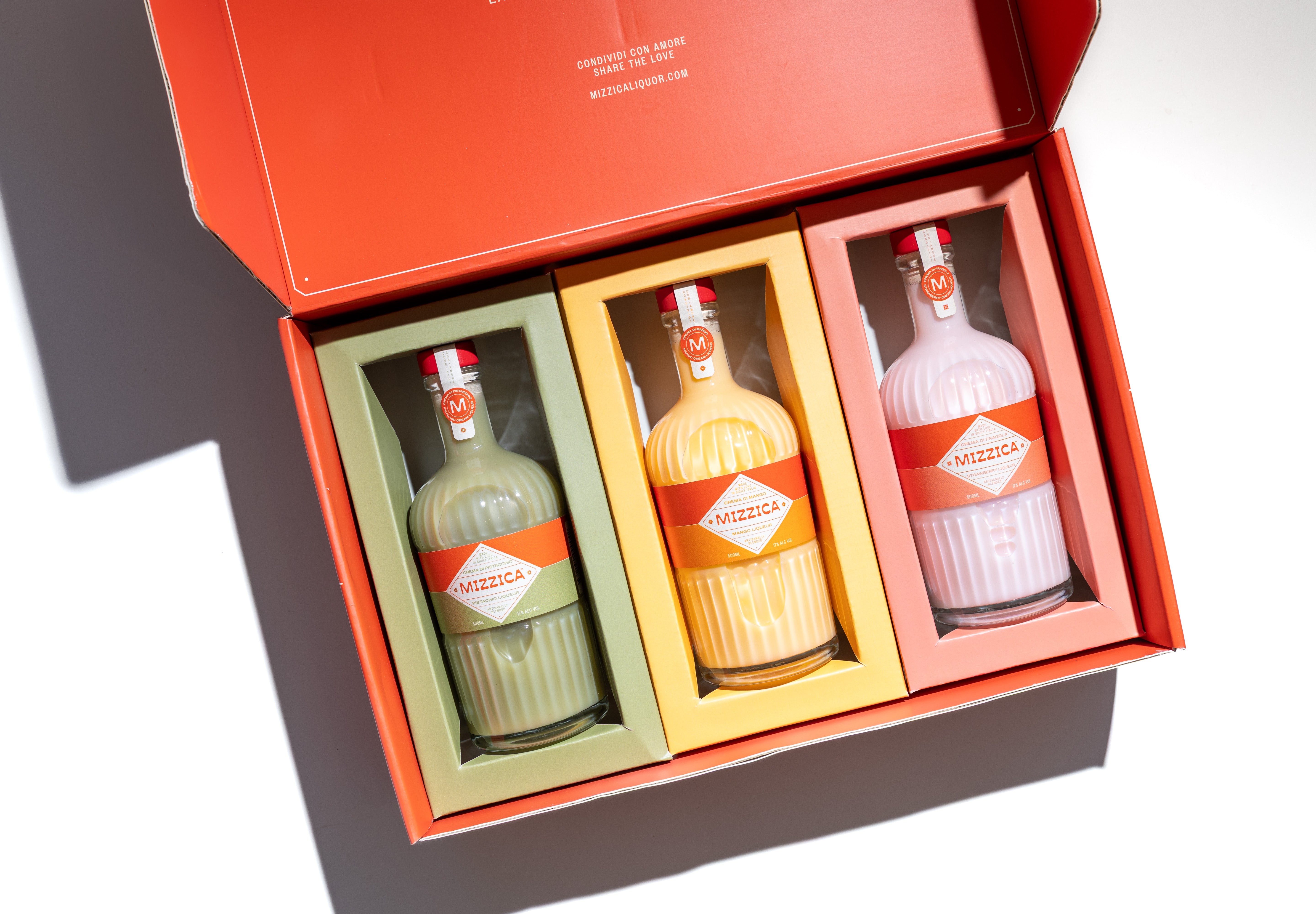 Three Mizzica liqueur bottles in a branded gift box.