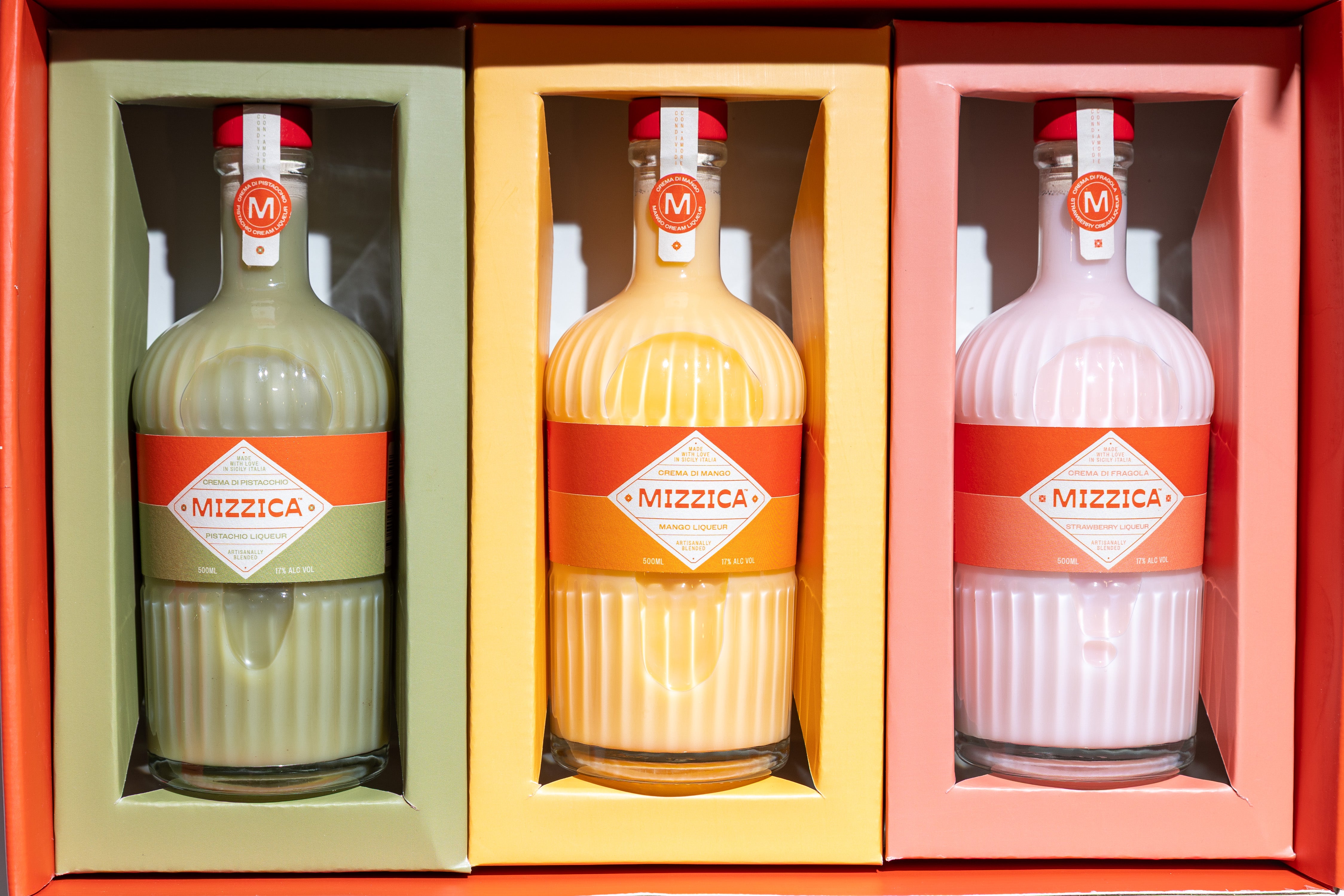 Three Mizzica liqueur bottles in a colored gift box.