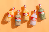 Five bottles of Mizzica liqueur bottles on a yellow background