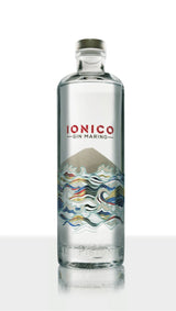 Clear glass bottle of Ionico Gin Marino on a white background