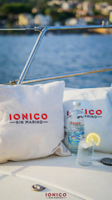 IONICO Gin Marino bottle and glass with lemon on a boat with scenic background