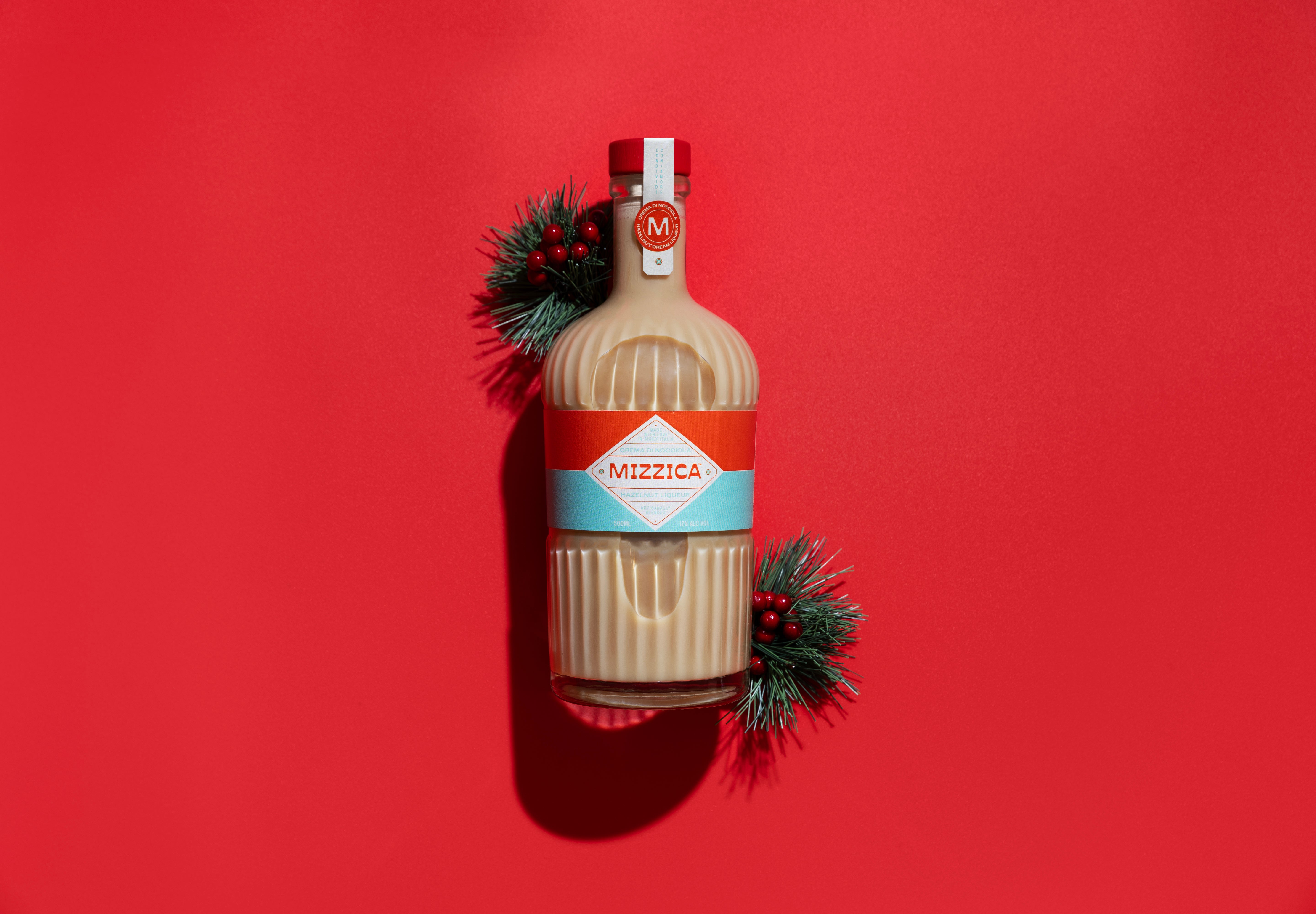 Bottle of Mizzica hazelnut liqueur on a red background