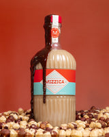 Bottle of Mizzica liqueur with chocolate drizzle on a red background