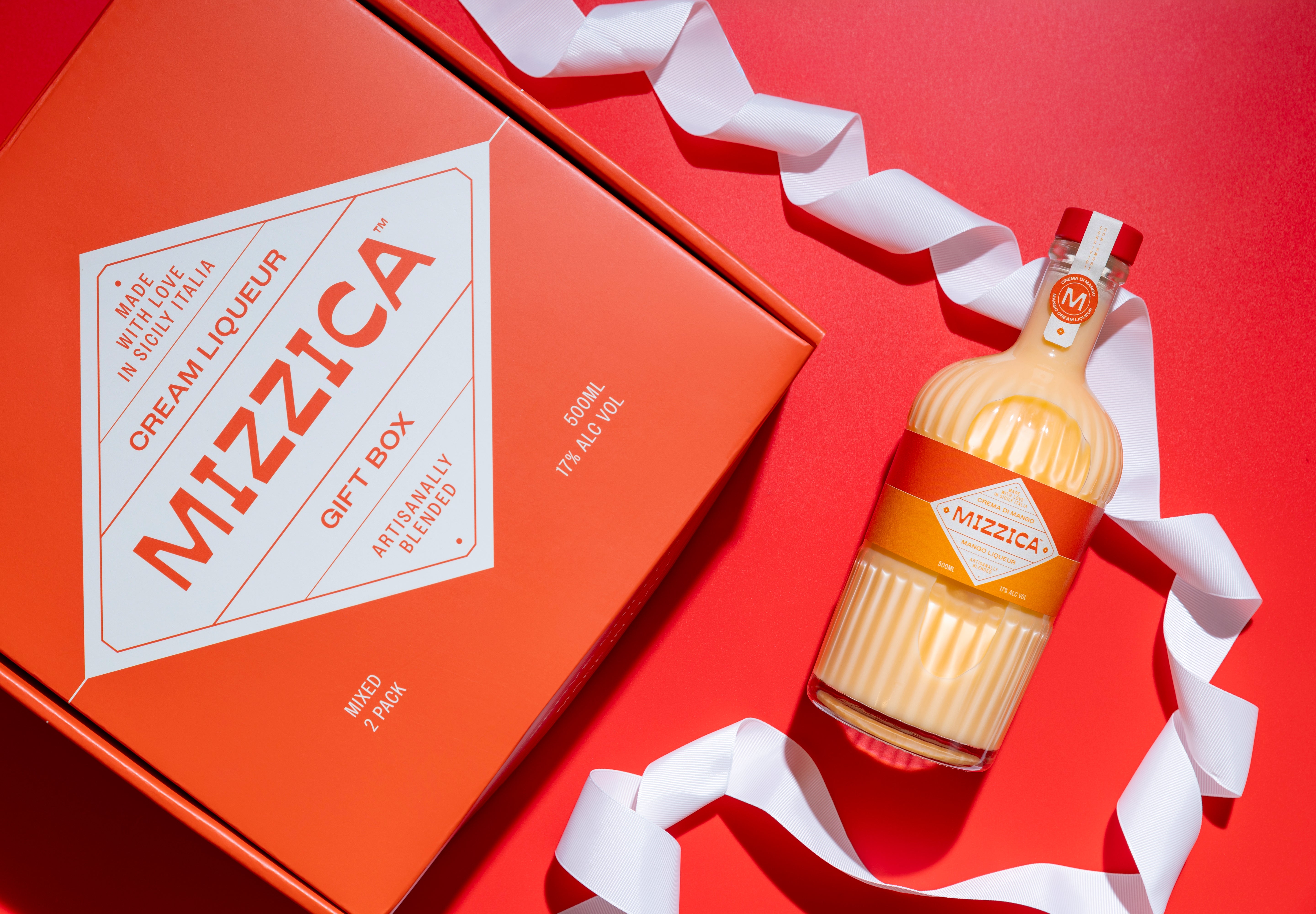 Mizzica mango liqueur bottle and packaging on a red background
