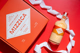 Mizzica mango liqueur bottle and packaging on a red background