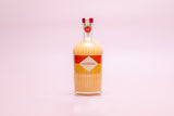 Bottle of Mizzica rockmelon liqueur on a pink background