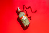 Mizzica pistachio liqueur bottle with a red ribbon on a red background