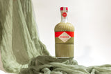 Bottle of Mizzica pistachio liqueur on a green fabric background