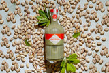 Mizzica pistachio liqueur bottle with pistachios on a light background